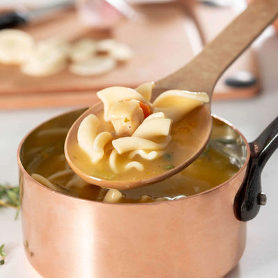 Epicurean Kitchen Series Large Spoon in Natural scooping up chicken noodle soup